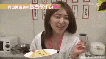 a woman is holding a plate of food with chinese writing on the wall behind her