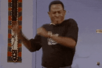 a man wearing a black shirt is dancing in front of a blue door