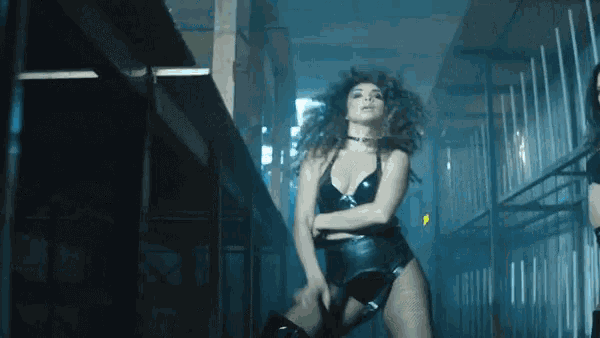 a woman in a tight black outfit is dancing