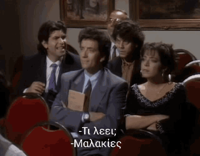 a group of people sitting in red chairs with the words " ti leei malakies " written in white