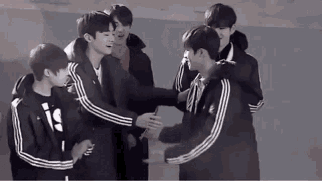 a group of young men are hugging each other .