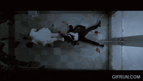 a man in a suit is laying on the floor with a gifrun.com watermark