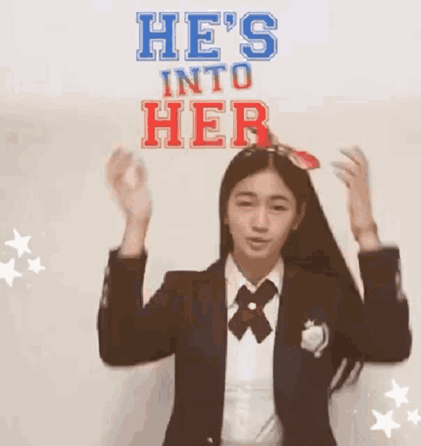 a girl in a school uniform is holding a sign that says he 's into her on her head