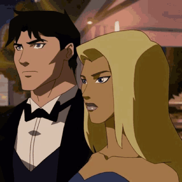 a man in a tuxedo stands next to a woman in a dress