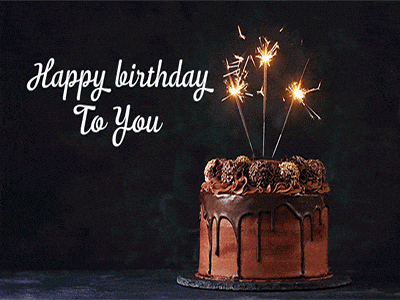 a chocolate birthday cake with sparklers and the words happy birthday to you on the bottom