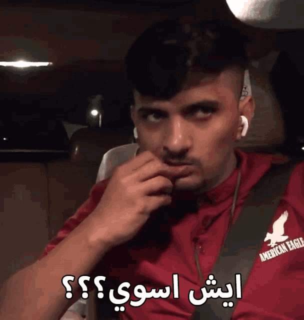 a man wearing an american eagle shirt with arabic writing on it