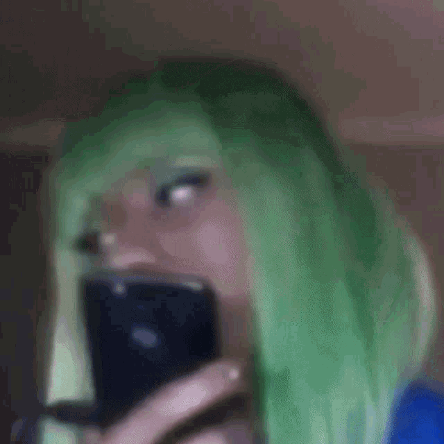 a woman in a green wig is laughing with her mouth open