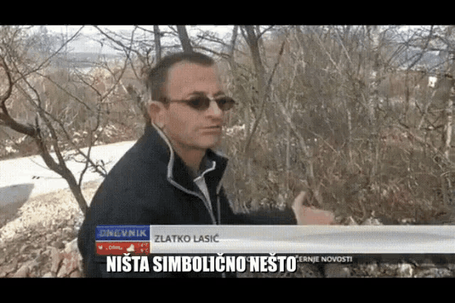 a man wearing sunglasses stands in front of a sign that says zlatko lasic on it