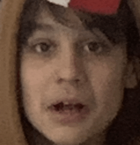 a close up of a person 's face with a santa hat on their head .