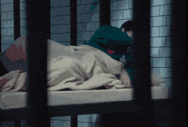 a person laying on a bed with a green shirt that says ss