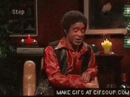 a man in a red shirt is drinking from a glass ..