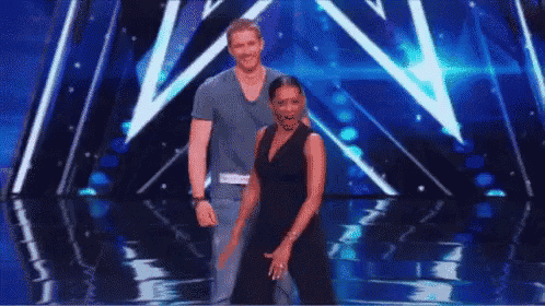 a man and a woman are dancing on a stage in front of a crowd .