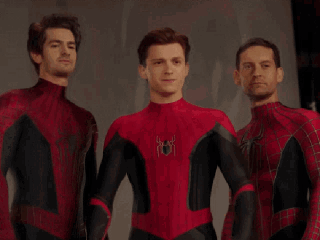 three men in spiderman costumes are posing for a picture