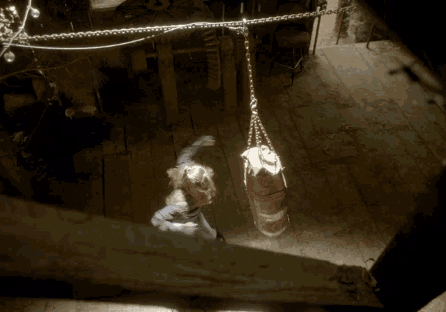 a person is hanging from a chain in a room