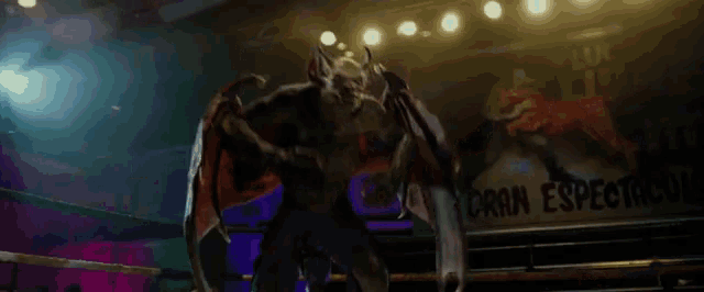 a monster with wings is fighting a man in a boxing ring .