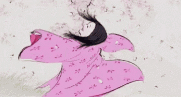 a woman in a pink dress is standing in front of a tree with cherry blossoms .