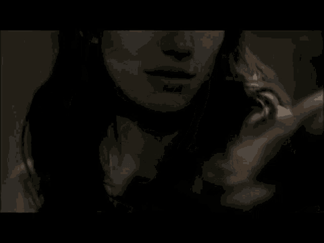 a close up of a woman 's face in a dark room with her eyes closed .