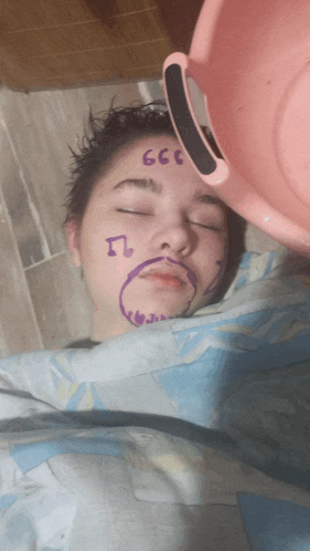 a girl with 666 written on her face is laying in bed
