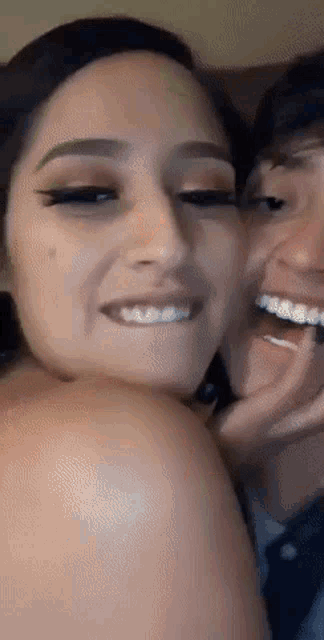 a man kisses a woman on the cheek and they both smile
