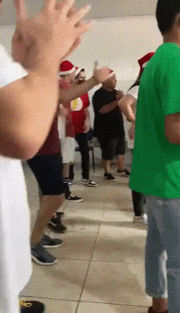a group of people wearing santa hats clapping their hands