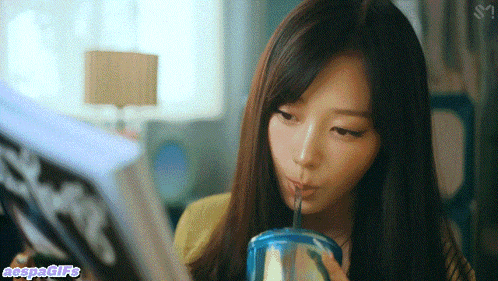 a woman drinking through a straw while reading a magazine with the word negative written below her