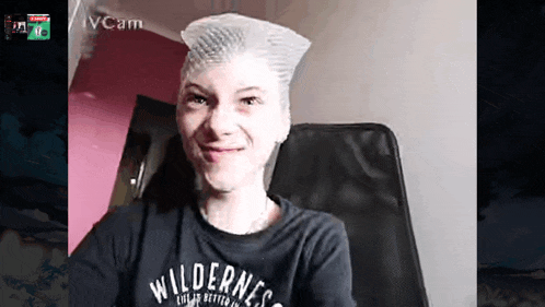 a woman wearing a black shirt that says wilderness is smiling