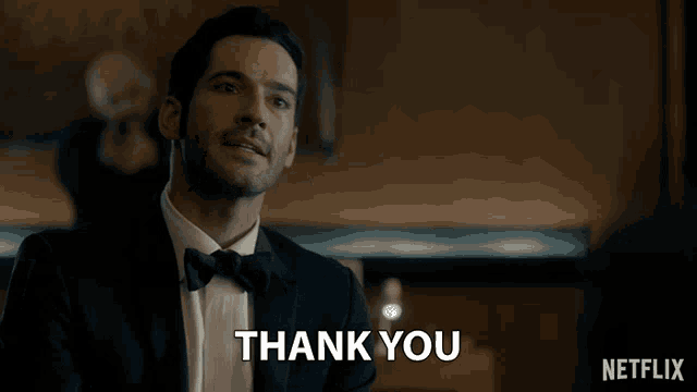 a man in a suit and bow tie is saying thank you