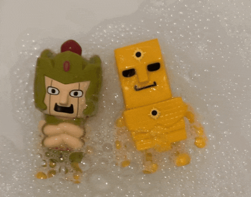 two toy figures are sitting in a bathtub filled with bubbles