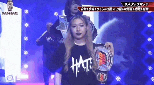 a woman wearing a shirt that says hat is holding a trophy