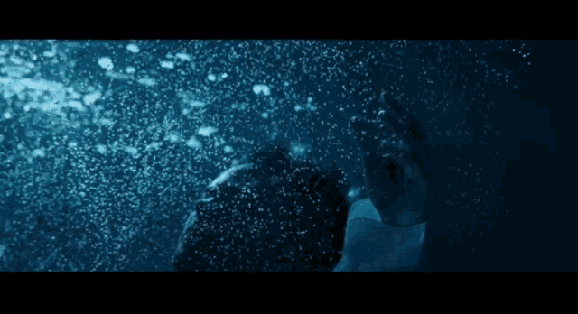 a person is swimming in the water and bubbles are coming out of the water