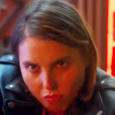 a close up of a woman 's face wearing a leather jacket .