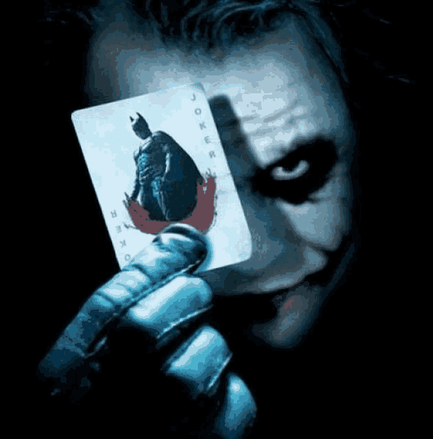 a person holding a joker card with a batman on it