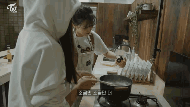 two girls are cooking in a kitchen with the word twice on the bottom right