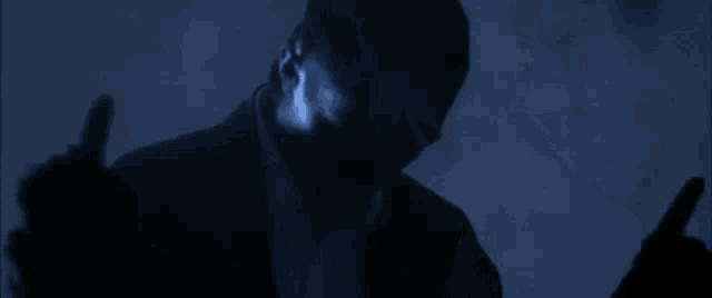 a man in a suit and bow tie is standing in a dark room in the dark .