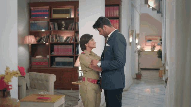 a man and a woman are standing next to each other in a room
