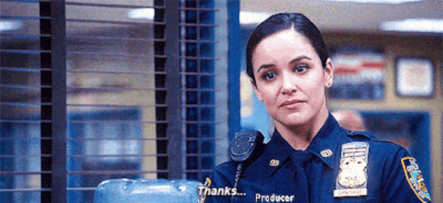 a woman in a police uniform is standing next to a water cooler and saying thanks .