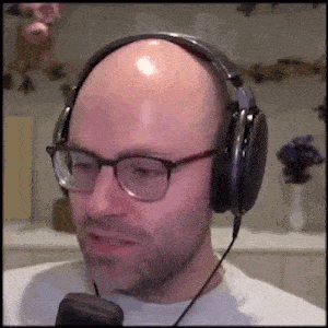 a bald man with glasses is wearing headphones and a microphone .