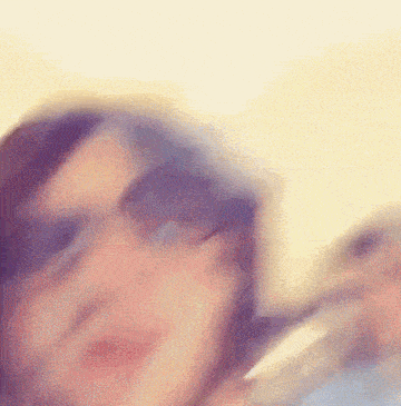 a blurry picture of a woman wearing sunglasses and a hat