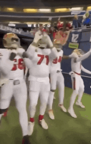 a group of football players are dancing in a stadium
