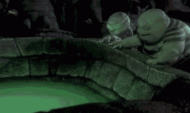 a nightmare before christmas scene with a glowing ball in the middle of a pool of green liquid .