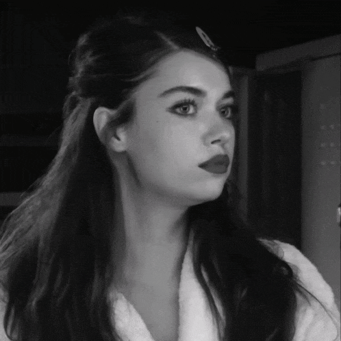 a black and white photo of a woman with long hair and red lipstick