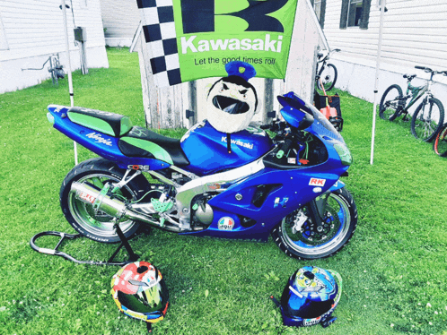 a blue kawasaki motorcycle is parked in front of a kawasaki banner