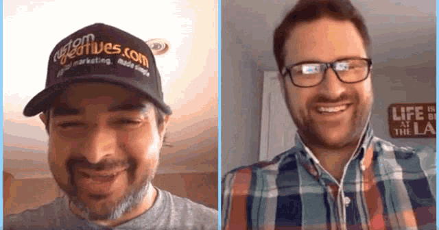 a man wearing a hat that says vegasfives.com smiles next to another man wearing glasses