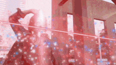 a woman in a red dress stands in front of a pink building