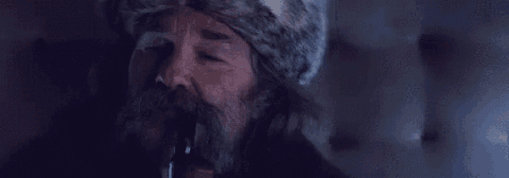 a man with a beard and a hat is crying with tears running down his face .