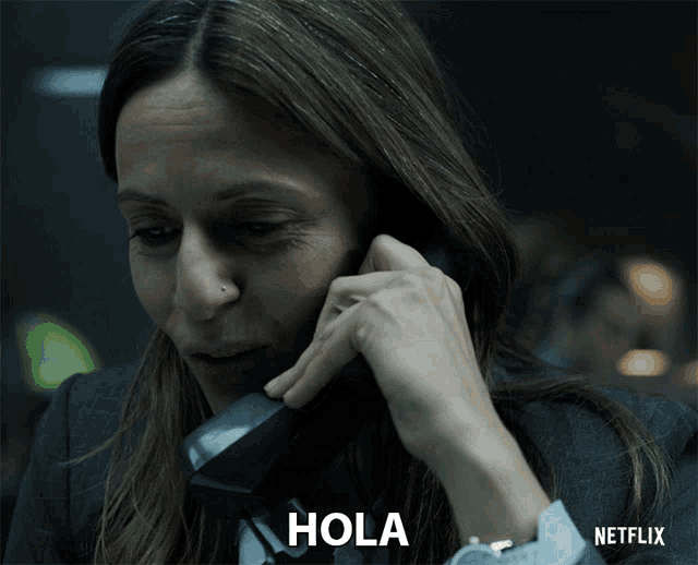 a woman is talking on a phone with the word hola written below her