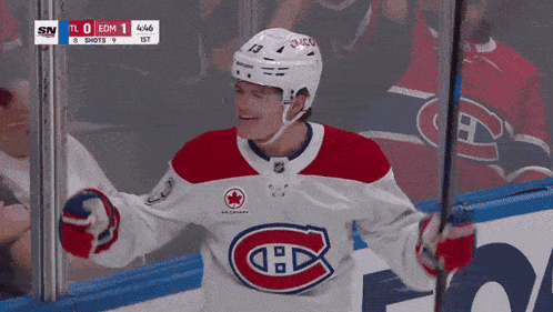 a hockey player in a red white and blue jersey with the number 13 on his helmet
