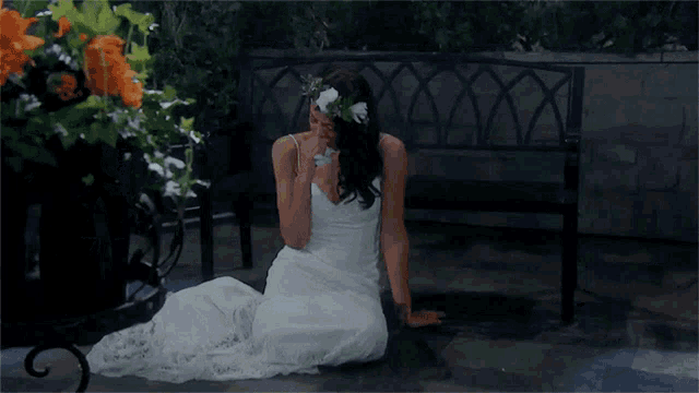 a woman in a white dress is sitting on the ground