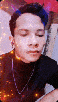 a young man with blue hair is wearing a black shirt and a silver chain around his neck