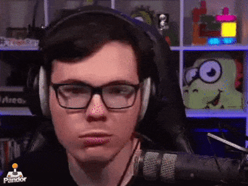a man wearing glasses and headphones is sitting in front of a microphone